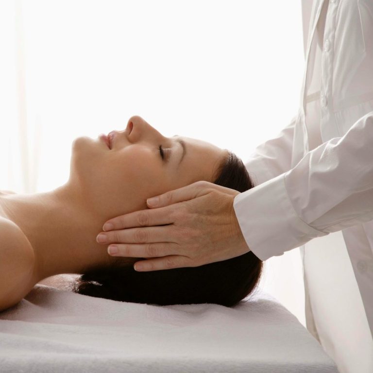Healing - Reiki behandeling Een vrouw ontvangt een ontspannende energetische behandeling